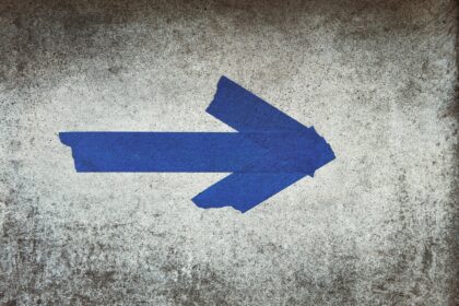 blue arrow sign on gray textile