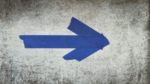 blue arrow sign on gray textile